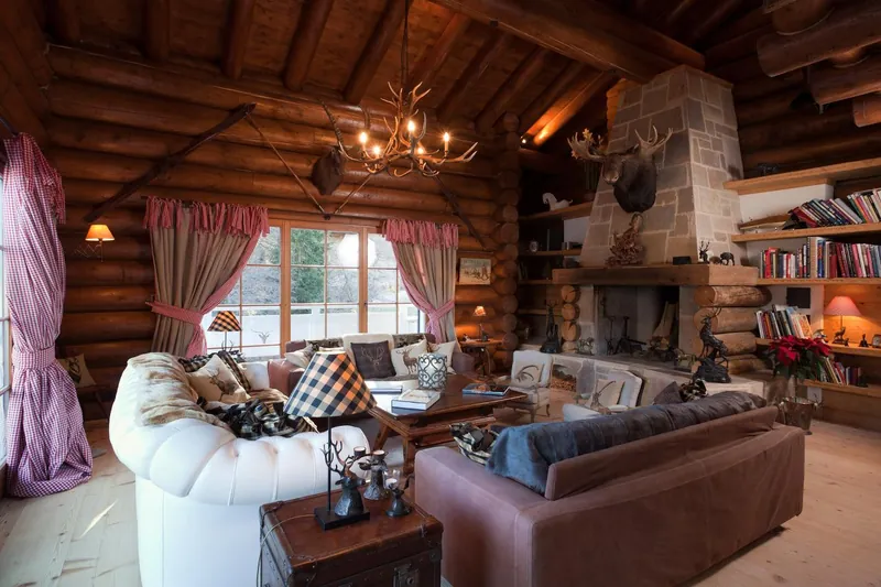 The log-built living room at Chalet Magan with an open fireplace